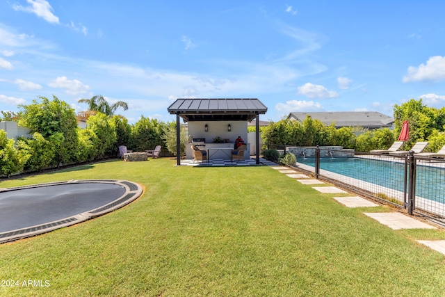 view of yard featuring a bar, a fenced in pool, a trampoline, and a patio