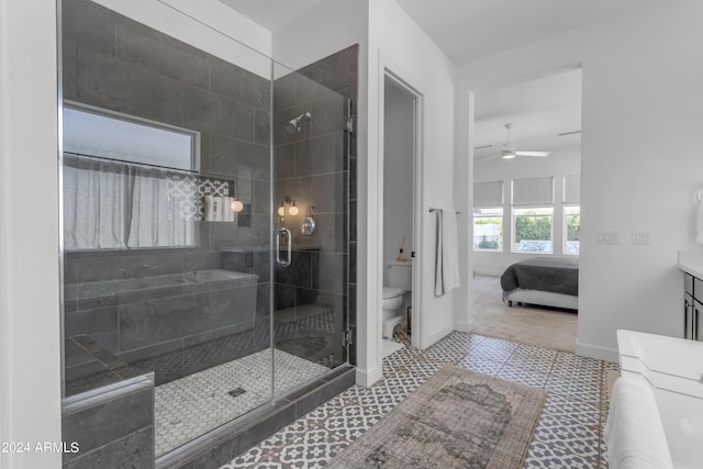 bathroom featuring ceiling fan, a shower with door, vanity, and toilet