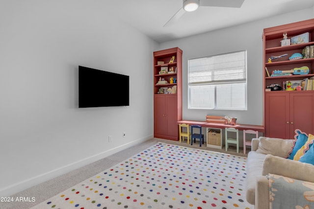 recreation room with light carpet and ceiling fan