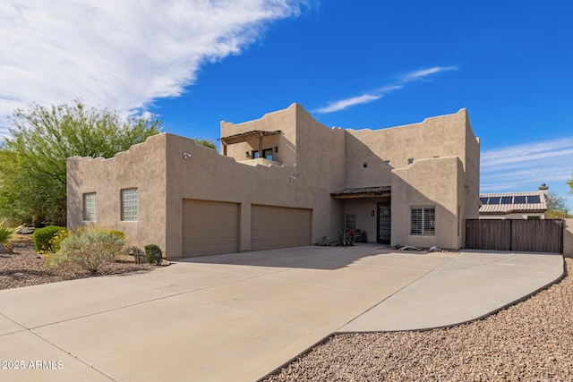 pueblo-style house featuring a garage