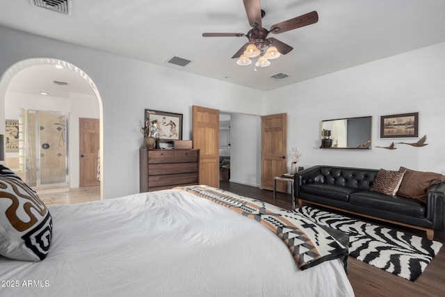 bedroom with ensuite bath, ceiling fan, and light hardwood / wood-style flooring