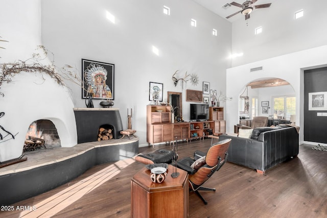 living room featuring dark hardwood / wood-style floors, ceiling fan, and a high ceiling