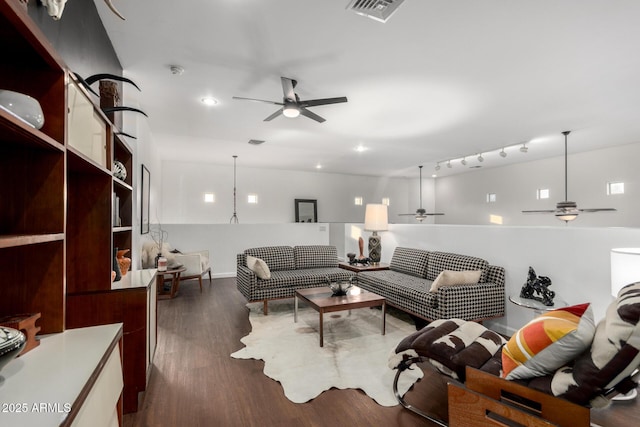 living room featuring dark wood-type flooring and ceiling fan