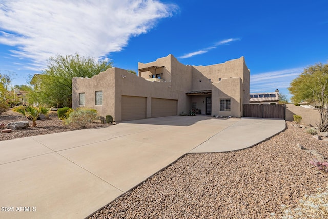 pueblo revival-style home featuring a garage