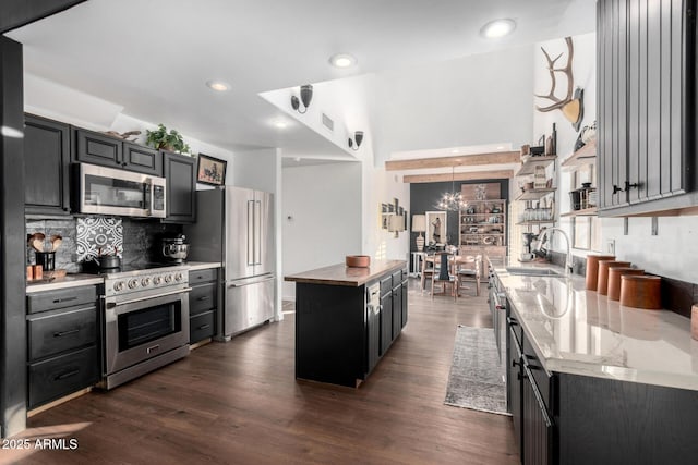 kitchen featuring high end appliances, a center island, sink, and dark hardwood / wood-style floors