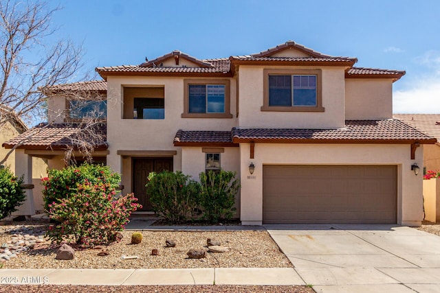 view of front of house featuring a tiled roof, stucco siding, and driveway
