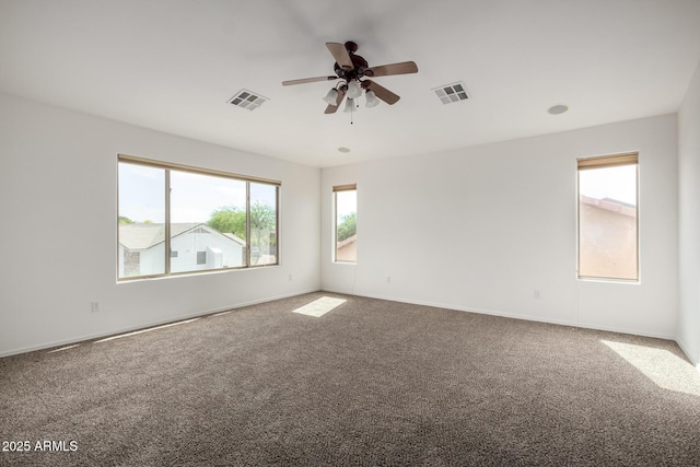 carpeted spare room featuring a ceiling fan, baseboards, and visible vents