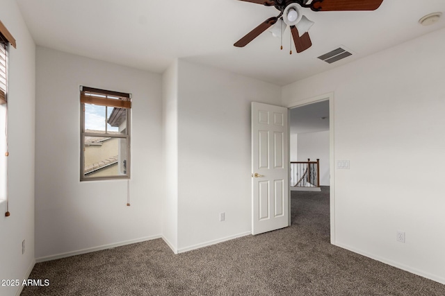 unfurnished room with baseboards, carpet, a ceiling fan, and visible vents