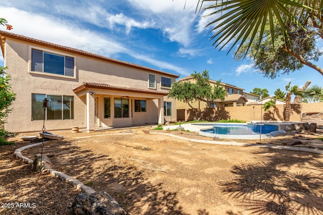 back of house with a fenced in pool, a fenced backyard, a patio area, and stucco siding