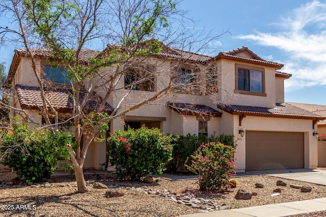 view of front facade with a garage, stucco siding, driveway, and a tile roof