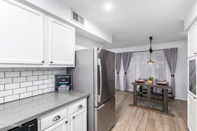 kitchen featuring light wood-type flooring, ornamental molding, stainless steel fridge, white cabinetry, and decorative light fixtures