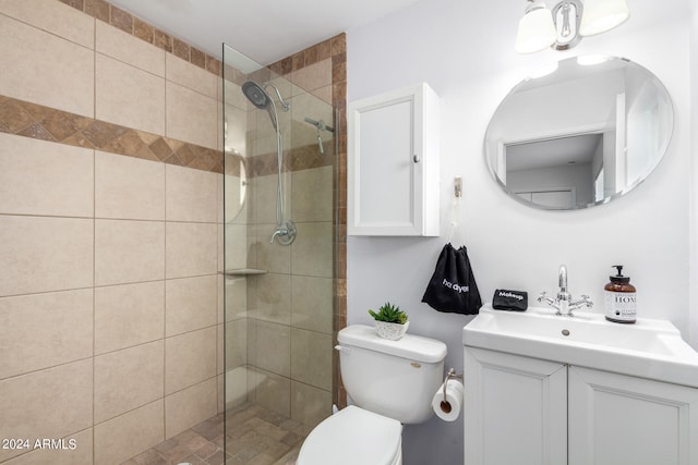 bathroom featuring vanity, toilet, and a tile shower