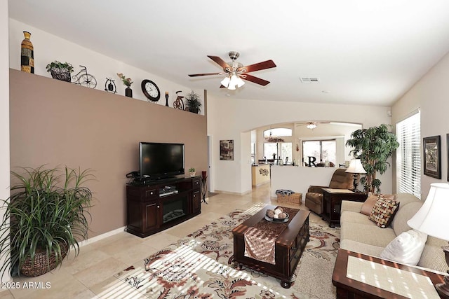 living room with ceiling fan, vaulted ceiling, and light tile patterned floors