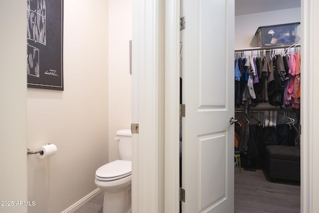 bathroom featuring wood-type flooring and toilet