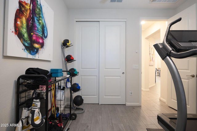 workout room with light hardwood / wood-style flooring