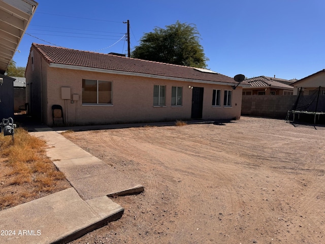 back of property featuring a trampoline