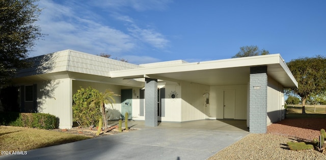 view of exterior entry with a carport and concrete driveway