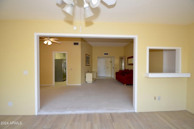 carpeted empty room with ceiling fan and visible vents