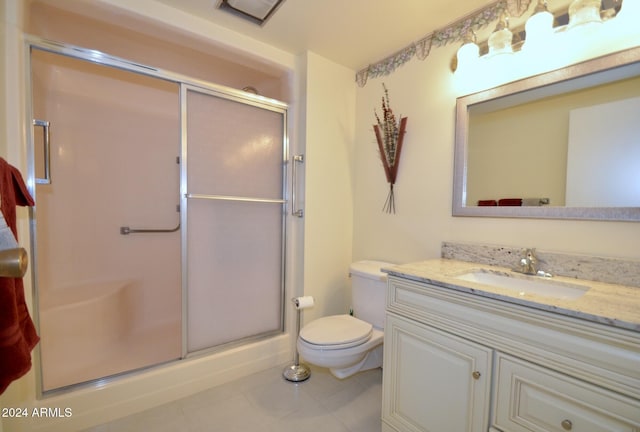 full bathroom featuring a stall shower, vanity, toilet, and tile patterned floors