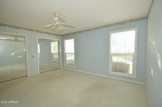 unfurnished bedroom featuring carpet floors, ceiling fan, a textured ceiling, and baseboards