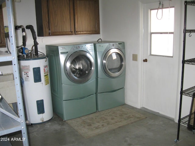 laundry area featuring water heater, washing machine and clothes dryer, and cabinet space