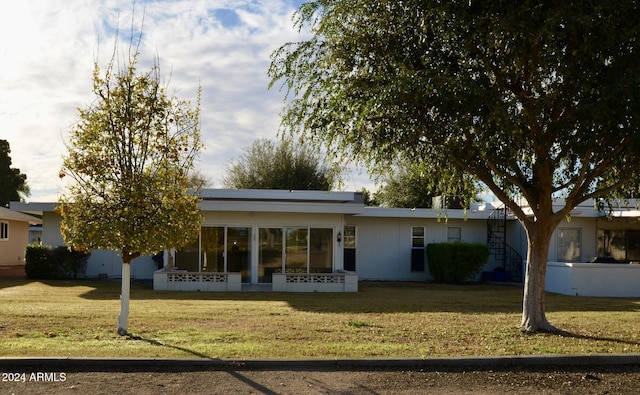 rear view of property featuring a lawn