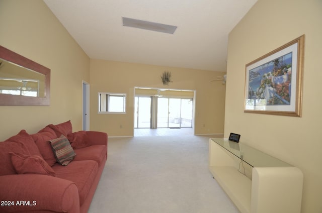 living area featuring light carpet, vaulted ceiling, and baseboards