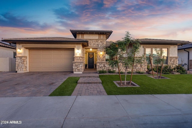 prairie-style house featuring stone siding, stucco siding, and driveway