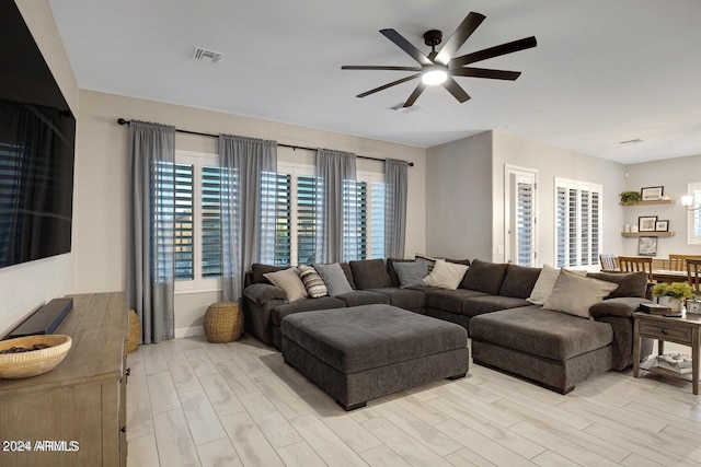 living room with ceiling fan and light hardwood / wood-style flooring