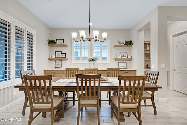 dining space featuring baseboards and an inviting chandelier