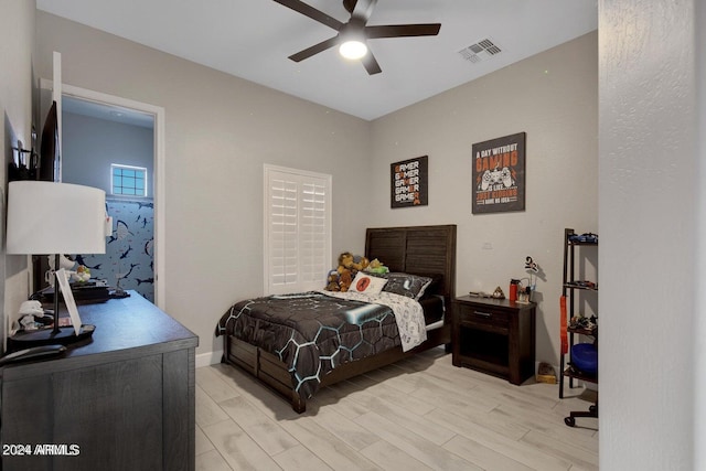 bedroom featuring light wood finished floors, visible vents, baseboards, and ceiling fan