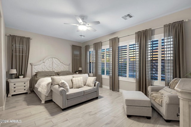 bedroom featuring visible vents, ceiling fan, baseboards, and light wood-style floors