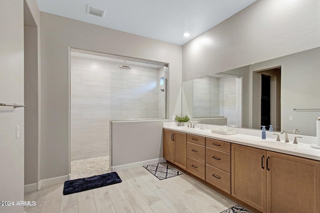 full bath with a sink, visible vents, double vanity, and a walk in shower