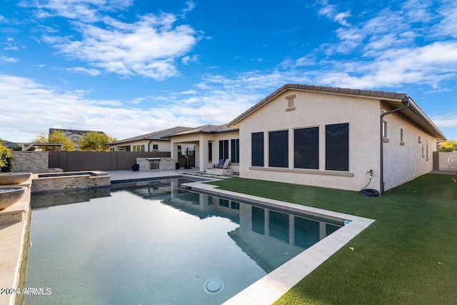 rear view of house with a patio, a fenced in pool, a yard, a fenced backyard, and stucco siding