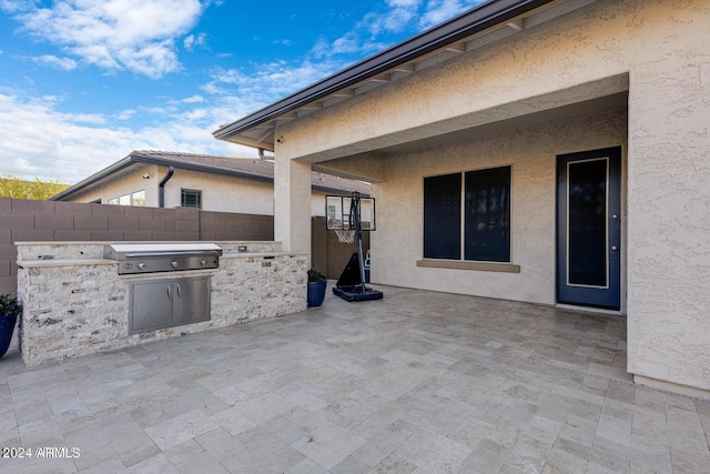 view of patio / terrace with a grill, exterior kitchen, and fence