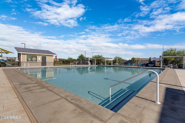 pool with a patio area and fence