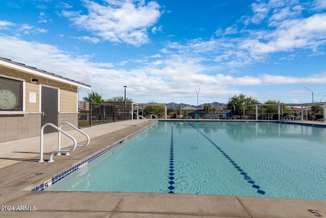 community pool with a patio and fence