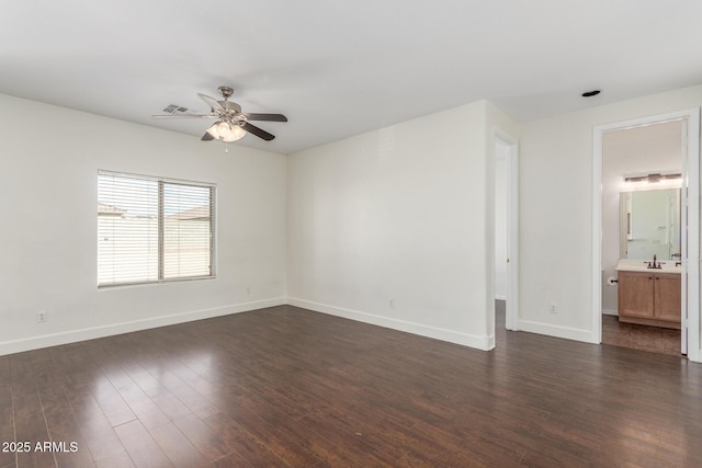 spare room with visible vents, baseboards, a ceiling fan, dark wood-type flooring, and a sink