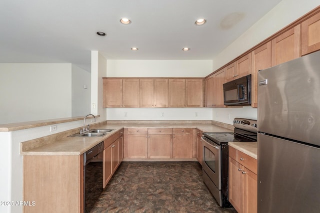 kitchen featuring recessed lighting, a peninsula, a sink, light countertops, and black appliances