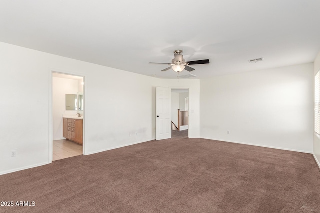 unfurnished bedroom with light carpet, baseboards, visible vents, and ensuite bathroom