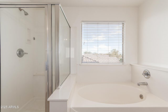 bathroom with a stall shower and a garden tub