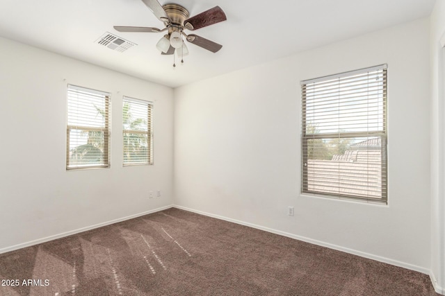 empty room featuring a ceiling fan, carpet, visible vents, and baseboards