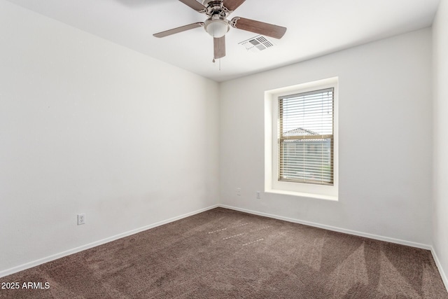 carpeted empty room featuring a ceiling fan, visible vents, and baseboards