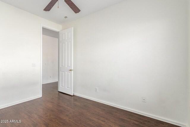 spare room featuring dark wood-type flooring, baseboards, and a ceiling fan