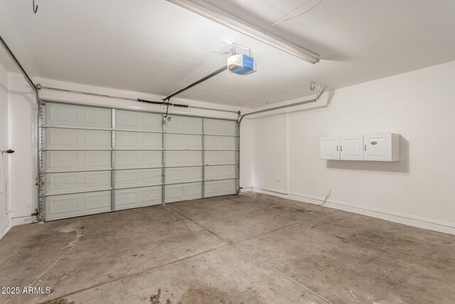 garage with baseboards and a garage door opener