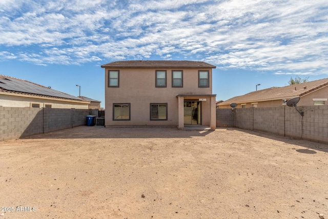 back of house with a fenced backyard and stucco siding