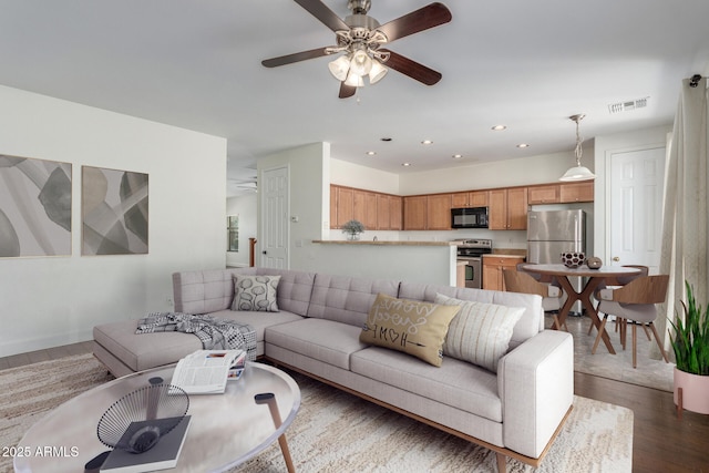 living room with dark wood-style floors, recessed lighting, visible vents, and ceiling fan