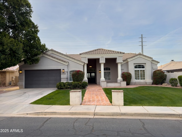 mediterranean / spanish-style house featuring a garage and a front lawn