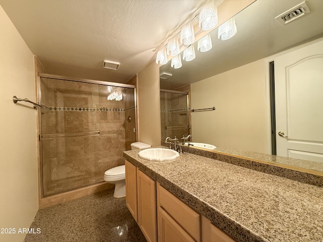 bathroom with vanity, a shower with shower door, a textured ceiling, and toilet