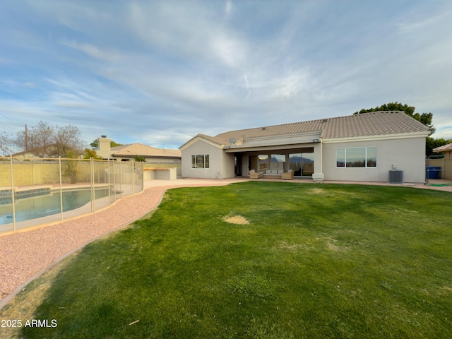 rear view of property with a fenced in pool, a patio area, central air condition unit, and a lawn